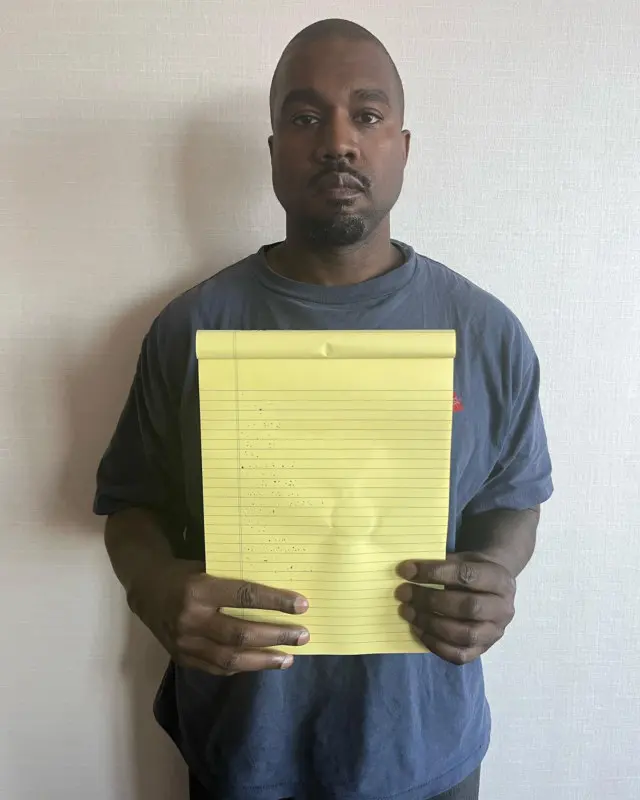 Kanye West with a yellow piece of paper blank meme template