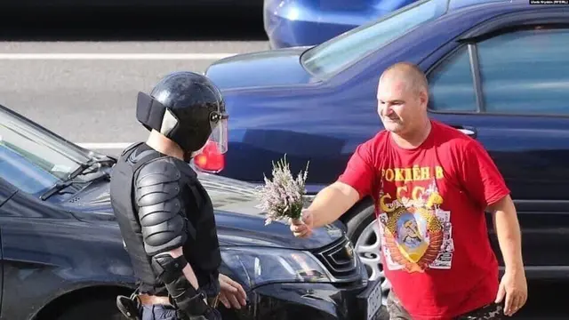A man gives flowers to a riot policeman meme template